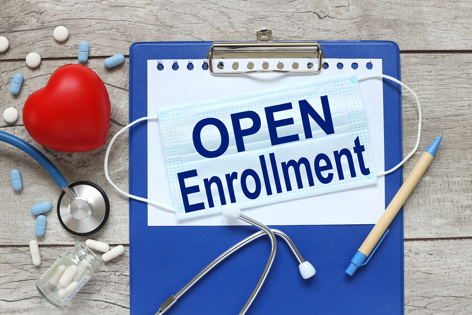 Clipboard holding a note with the words open enrollment